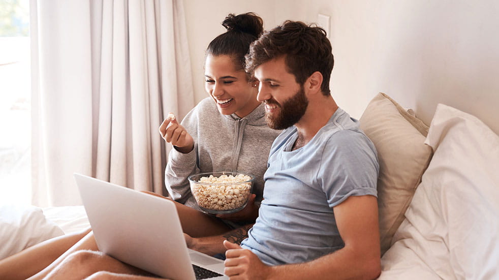 Christmas bubble couple watching movie on laptop